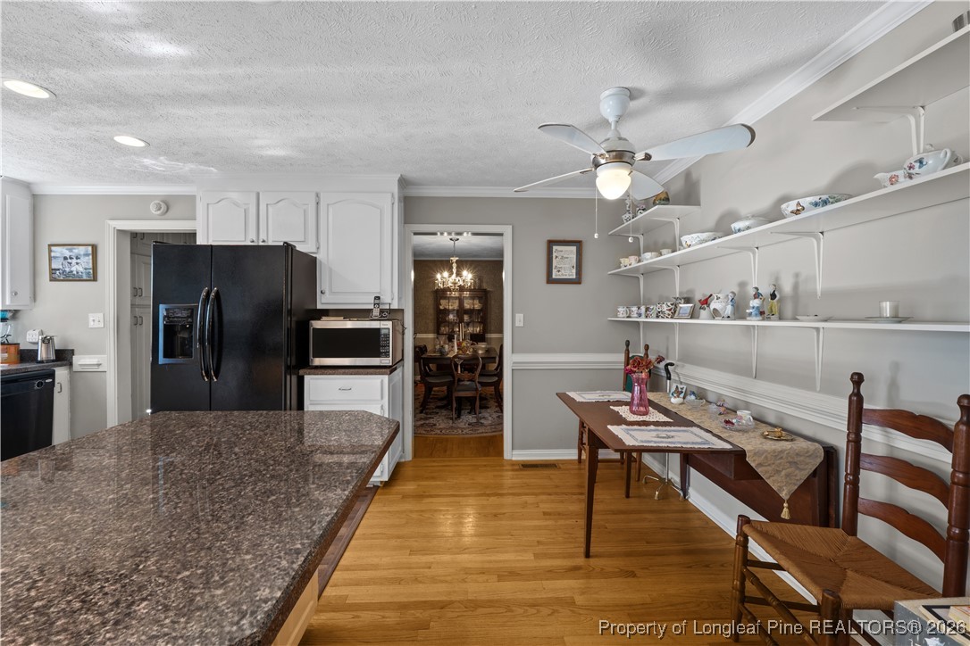 1717 Raeford Road Fayetteville, NC 28305 - Photo 6 of 25 a kitchen with stainless steel appliances kitchen island granite countertop a refrigerator a stove a sink dishwasher and a dining table with wooden floor