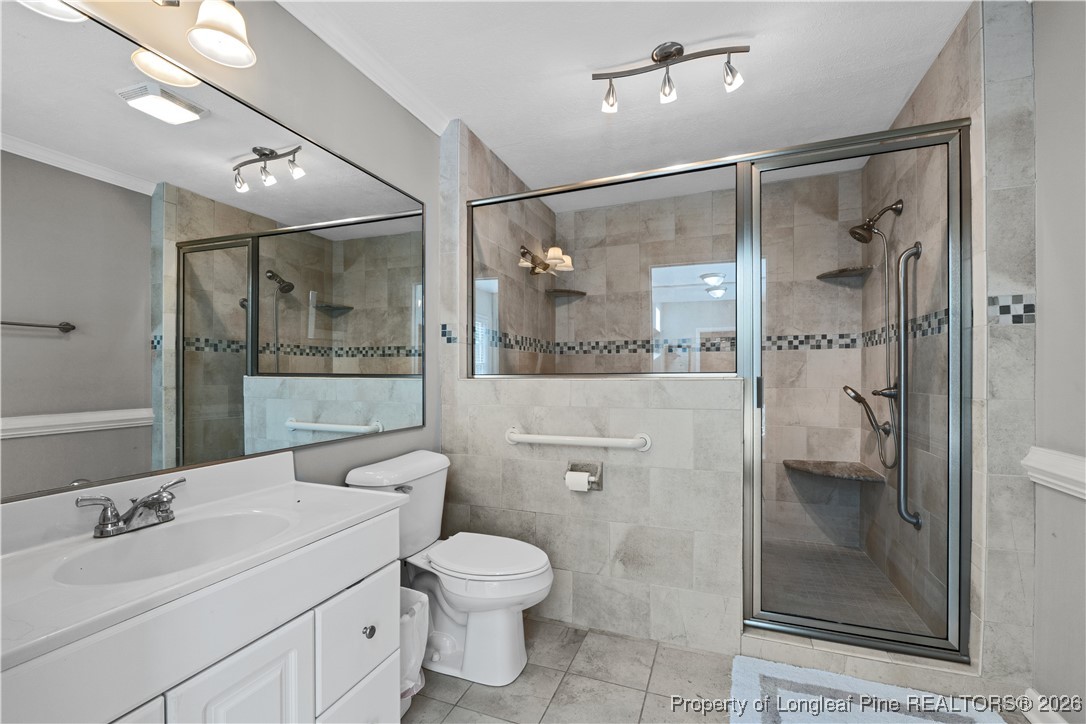 1717 Raeford Road Fayetteville, NC 28305 - Photo 9 of 25 a bathroom with a shower a sink and mirror with toilet