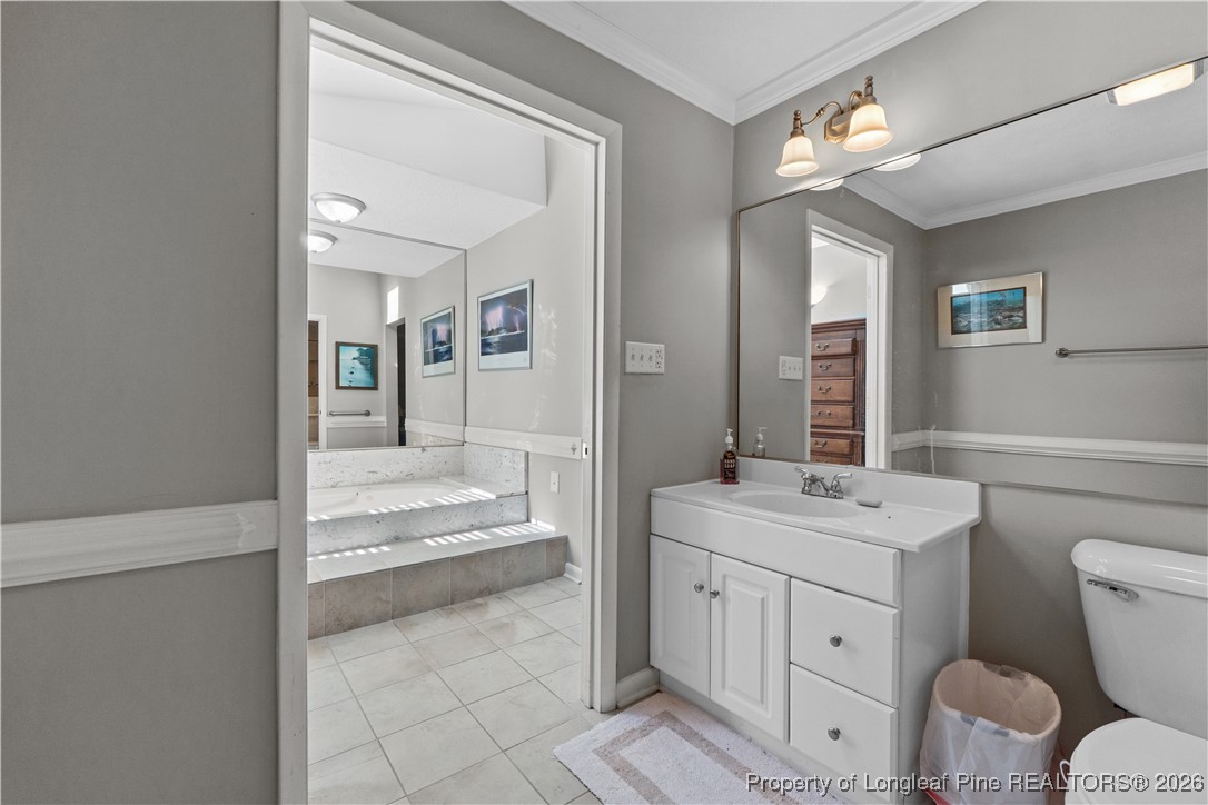 1717 Raeford Road Fayetteville, NC 28305 - Photo 10 of 25 a bathroom with a sink a toilet a mirror and vanity