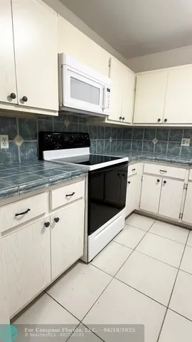 a kitchen with granite countertop a sink and a stove
