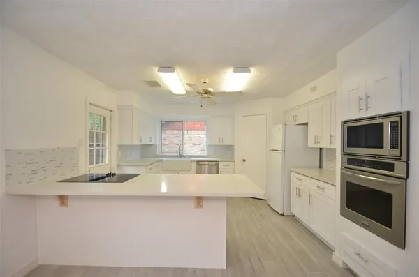 a large kitchen with kitchen island a large counter space stainless steel appliances and cabinets