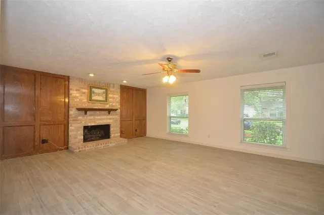 a view of an empty room with a fireplace and a window