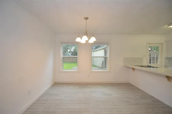 a view of a kitchen with a sink chandelier and a window