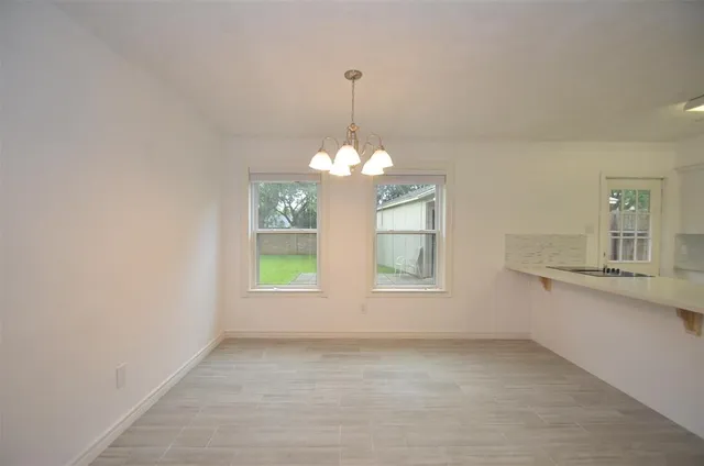 a view of a kitchen with a sink chandelier and a window