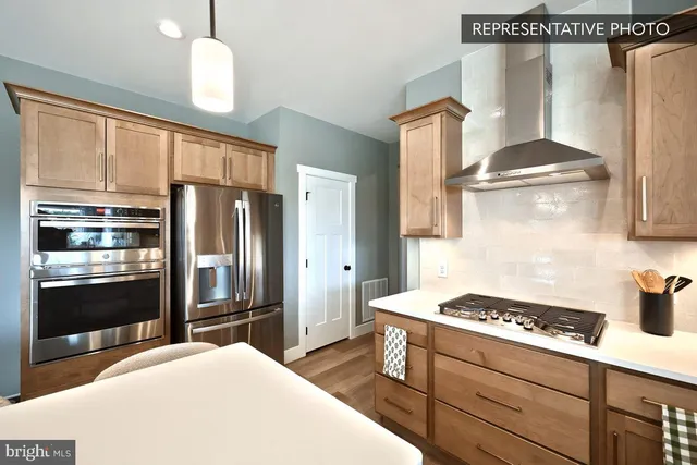 a kitchen with stainless steel appliances a stove a refrigerator and cabinets