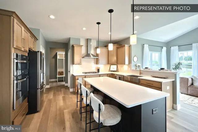 a kitchen with a sink appliances and wooden floor