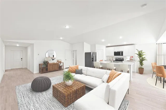 a living room with furniture a couch and a view of kitchen