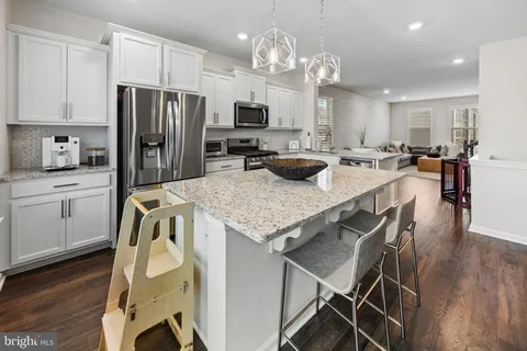 a kitchen with a dining table chairs and refrigerator