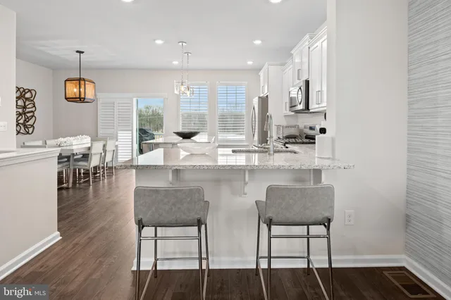 a kitchen with a table chairs refrigerator and microwave