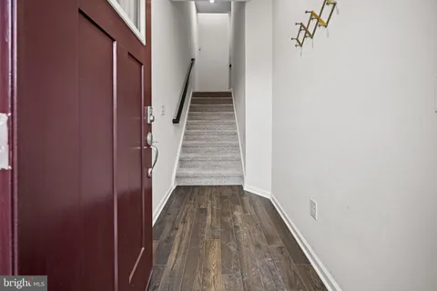a view of a hallway with wooden floor and entryway