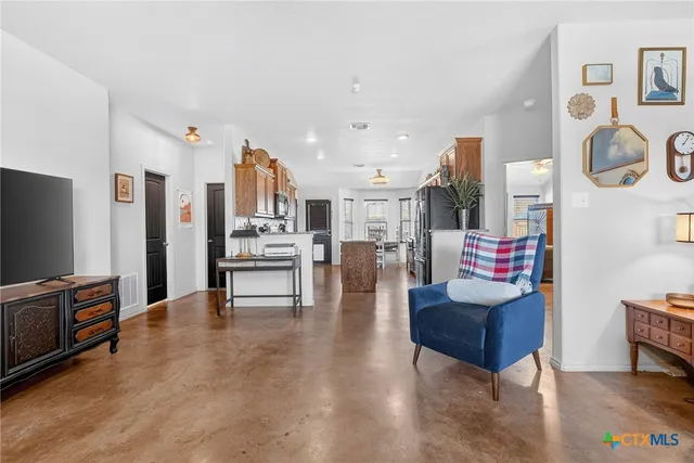a living room with furniture and kitchen view