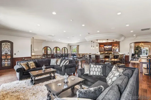 a living room with furniture a large window and a chandelier