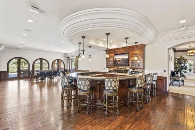 a spacious bathroom with a granite countertop sink a toilet a mirror and bathtub