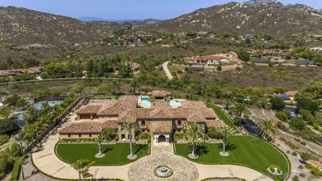 an aerial view of residential houses with outdoor space and trees