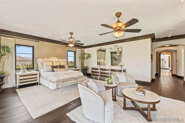 a bedroom with a large bed and a chandelier