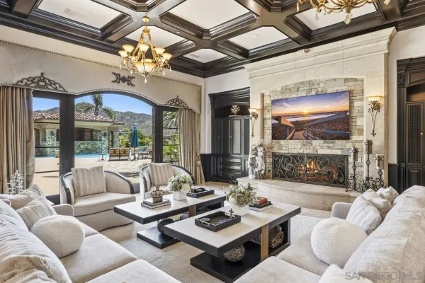a living room with furniture a chandelier and a large window