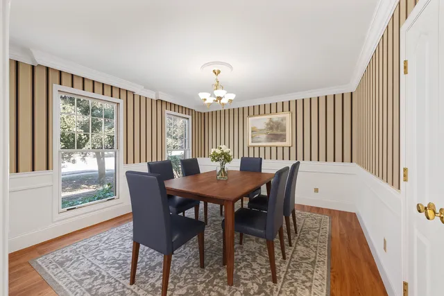 an empty room with chandelier fan and windows
