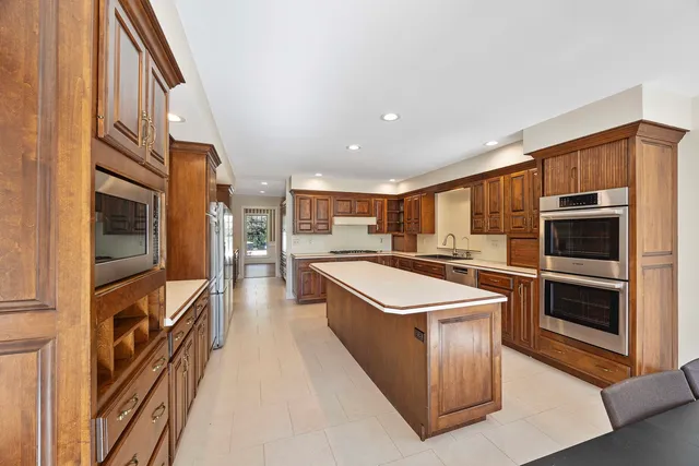 a view of a kitchen with furniture and stainless steel appliances