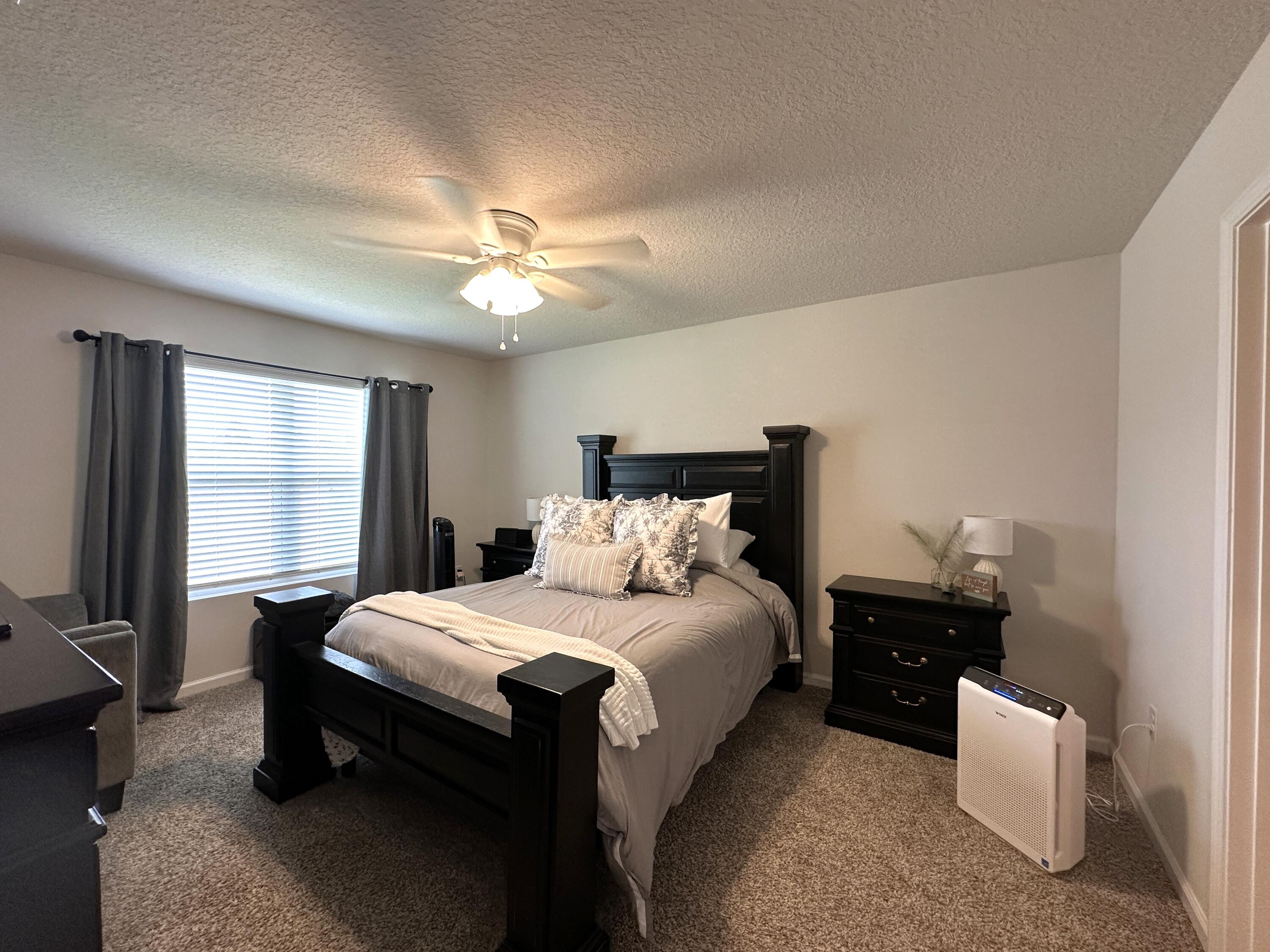 828 Otto Loop Crestview, FL 32539 - Photo 12 of 30 a bedroom with a bed and a chandelier