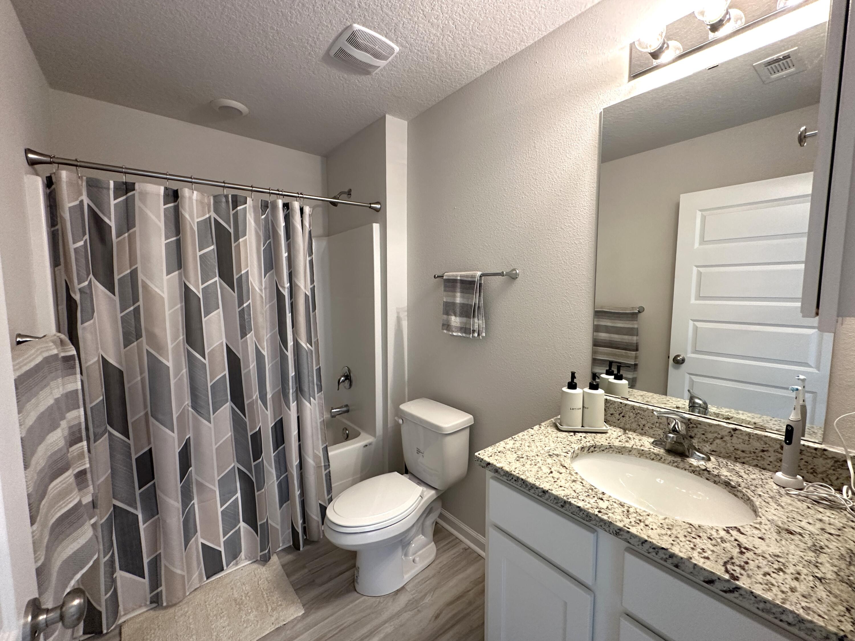 828 Otto Loop Crestview, FL 32539 - Photo 20 of 30 a bathroom with a granite countertop sink toilet and shower