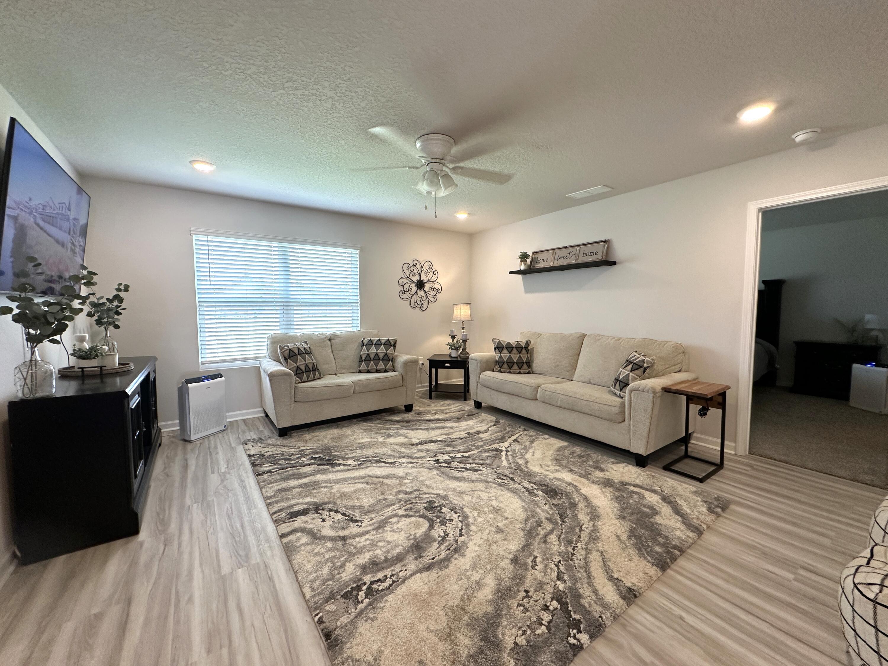 828 Otto Loop Crestview, FL 32539 - Photo 3 of 30 a living room with furniture and a large mirror with wooden floor