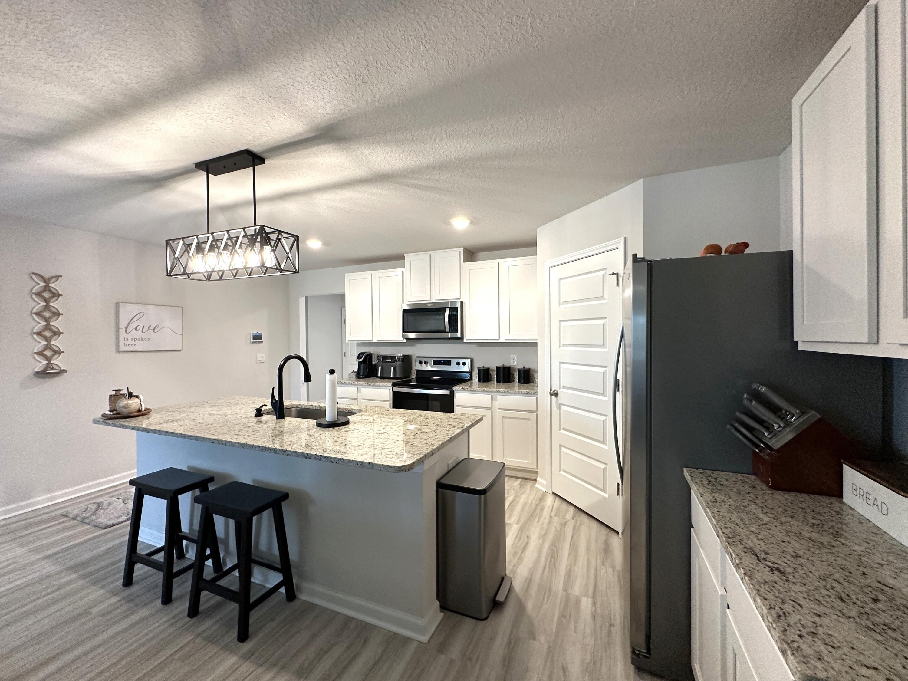 828 Otto Loop Crestview, FL 32539 - Photo 8 of 30 a kitchen with kitchen island granite countertop a sink a counter space stainless steel appliances and cabinets