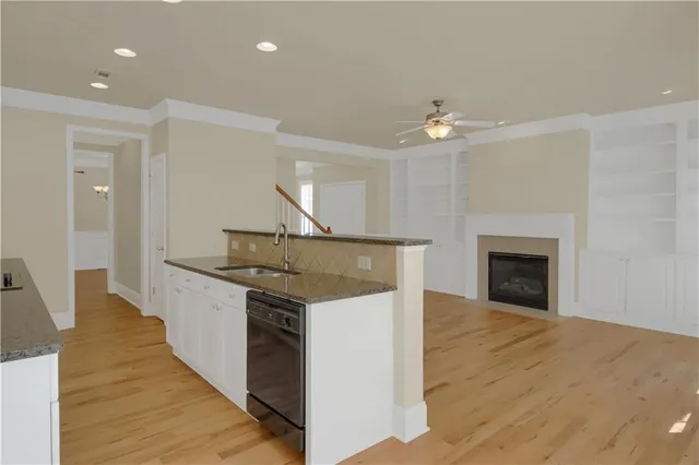 an open kitchen with fireplace and wooden floor