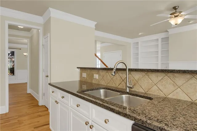 a kitchen with granite countertop a sink and a wooden cabinets