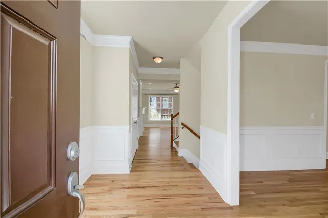 a view of a hallway with wooden floor and staircase