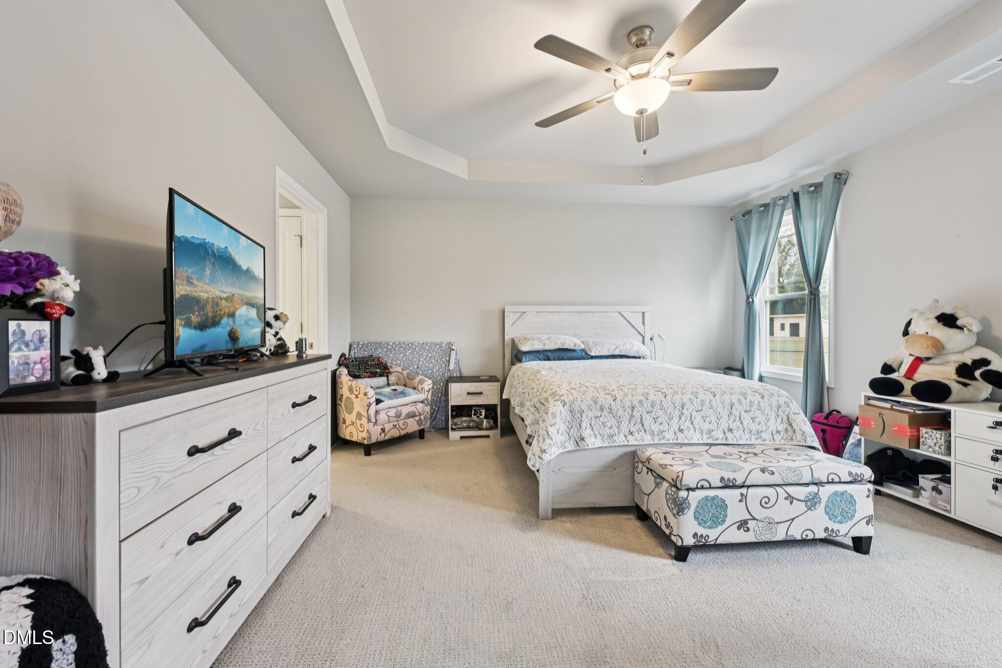 391 Byrdtown Road Benson, NC 27504 - Photo 12 of 28 a bedroom with a bed and a chandelier