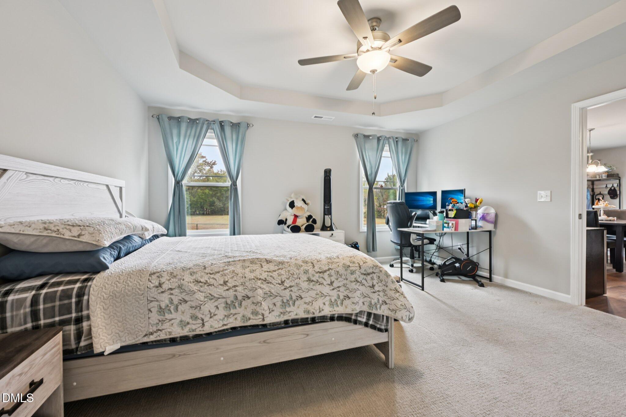 391 Byrdtown Road Benson, NC 27504 - Photo 13 of 28 a bedroom with a bed and a chandelier