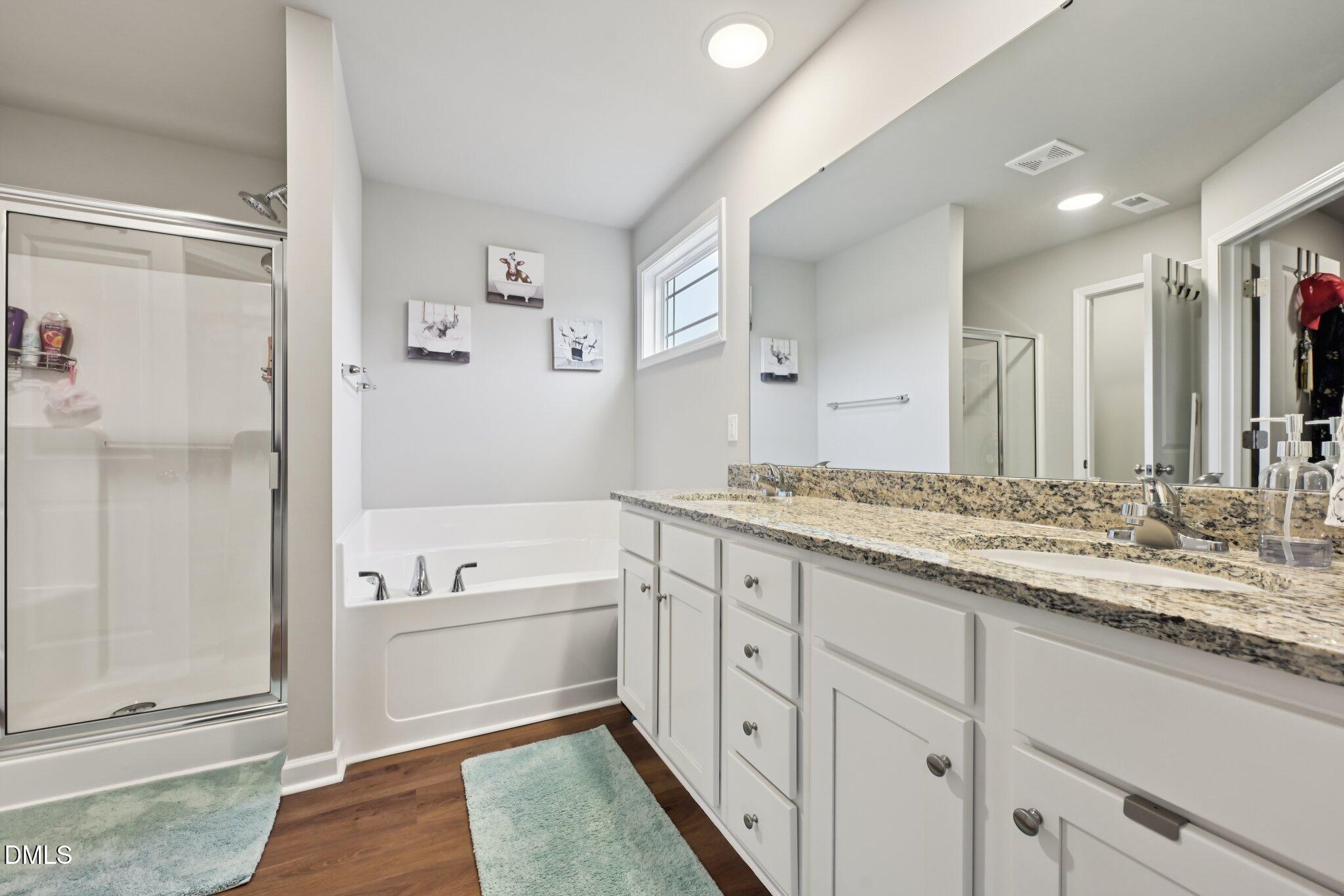 391 Byrdtown Road Benson, NC 27504 - Photo 14 of 28 a bathroom with a granite countertop double vanity sink a mirror and a bathtub