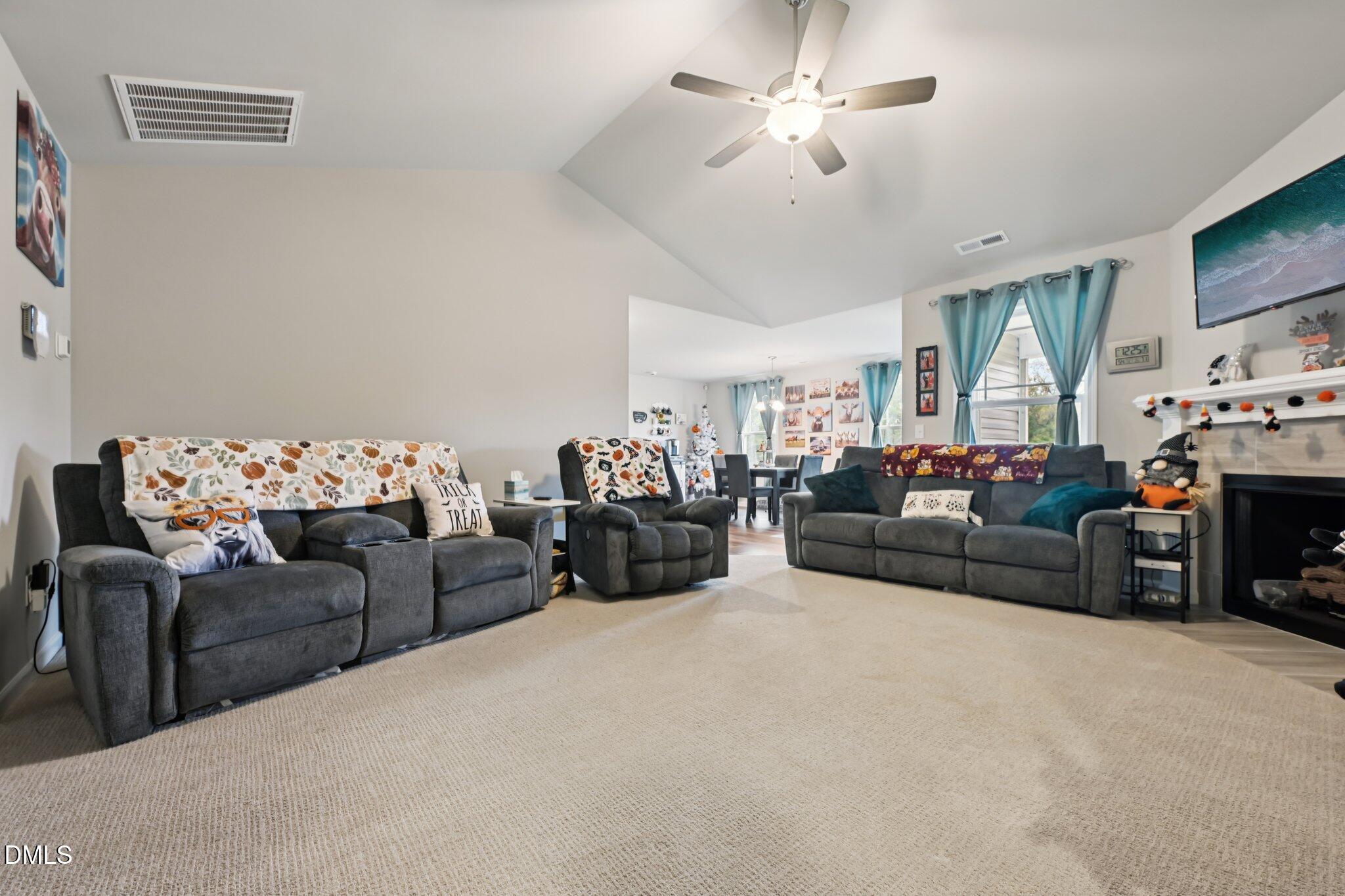 391 Byrdtown Road Benson, NC 27504 - Photo 4 of 28 a living room with furniture a chandelier fan and a fireplace