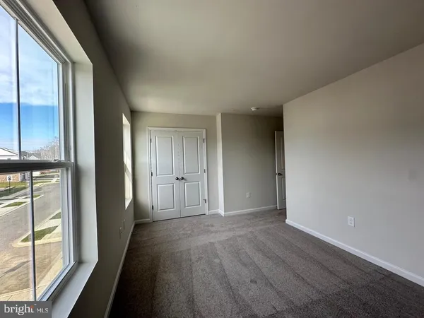 a view of hallway with a large window and wooden floor