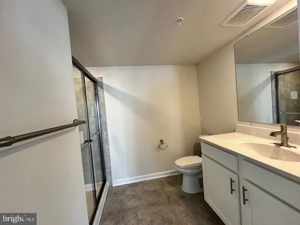 a bathroom with a sink a toilet a mirror and shower