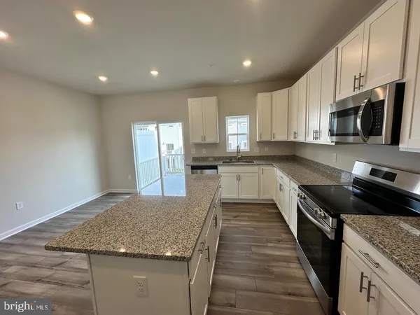 a large kitchen with stainless steel appliances granite countertop a sink stove and cabinets