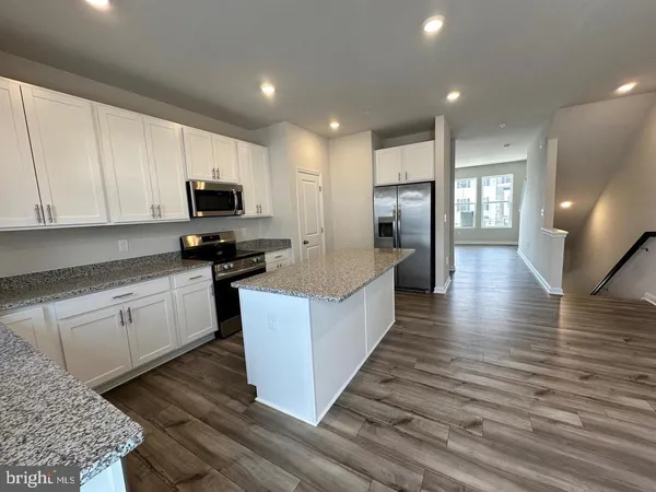 a large kitchen with stainless steel appliances granite countertop a stove a sink and a refrigerator