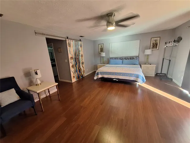 a bedroom with wooden floor and a bed