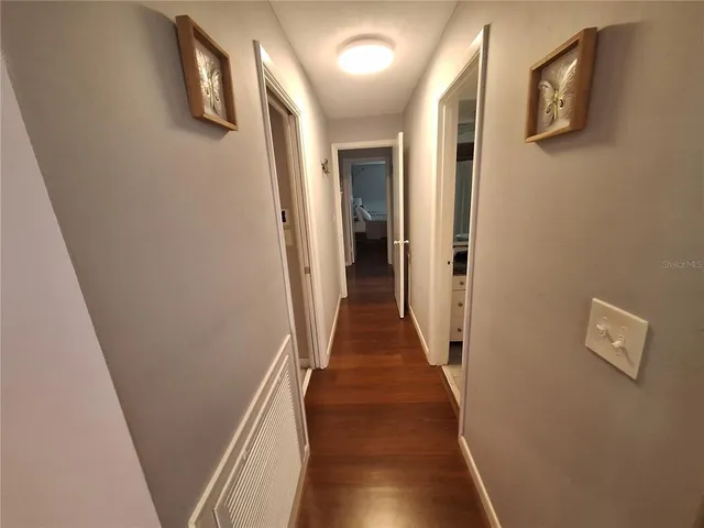 a view of a hallway with wooden floor and staircase