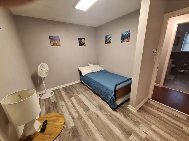 a bedroom with a bed and wooden floor