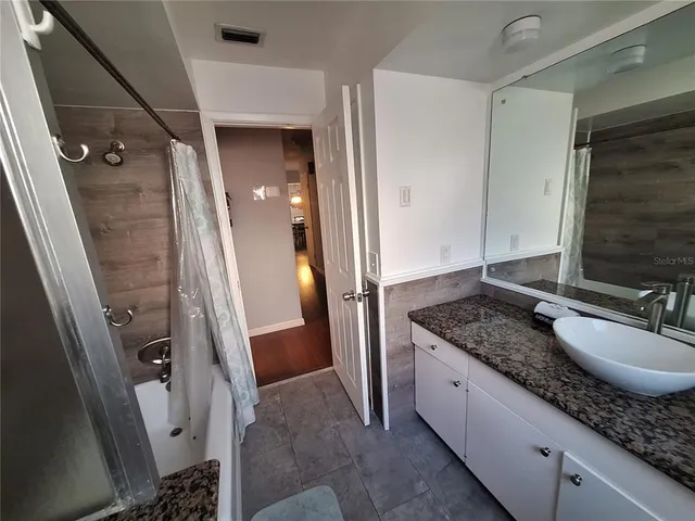a bathroom with a granite countertop sink and a mirror