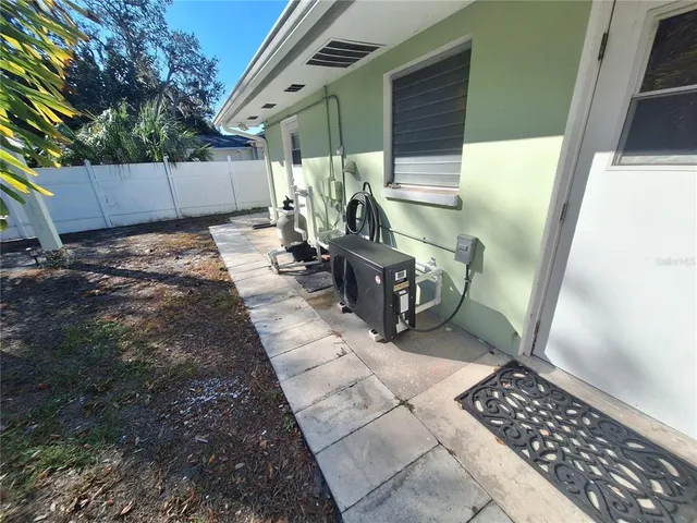 a view of a backyard with large trees and wooden fence