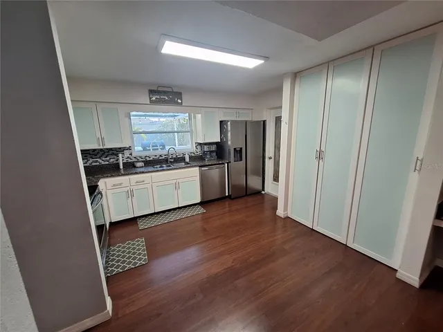 a kitchen with stainless steel appliances granite countertop wooden cabinets and a stove top oven