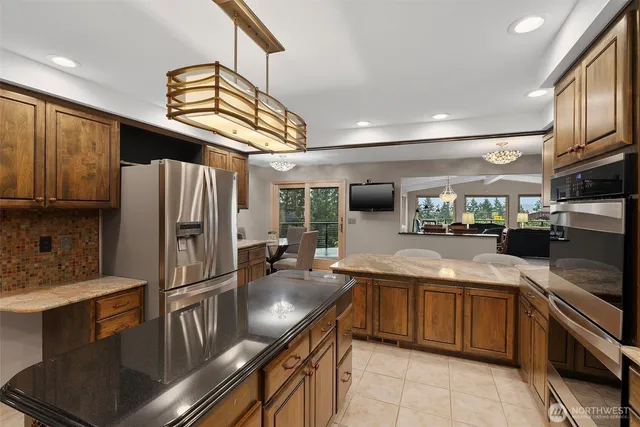 a kitchen with stainless steel appliances granite countertop a sink refrigerator and cabinets