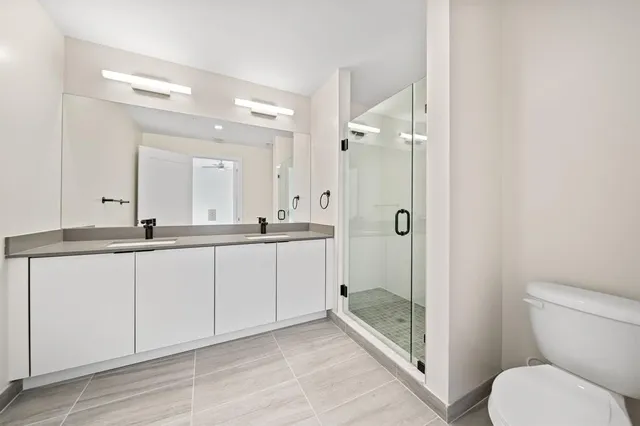 a bathroom with a granite countertop sink mirror and toilet