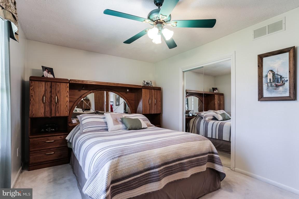 921 Emory Church Road Upperco, MD 21155 - Photo 16 of 30 a bedroom with a large bed and a chandelier