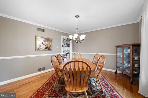 a dining room with furniture a chandelier and wooden floor