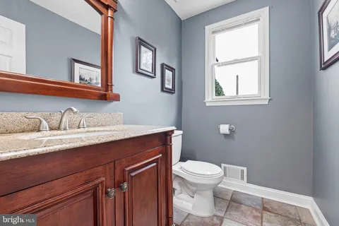 a bathroom with a granite countertop toilet sink and mirror
