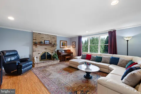 a living room with furniture a fireplace and large windows