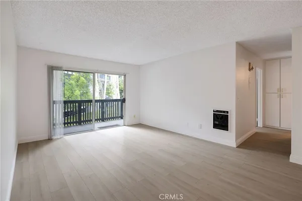 a view of a big room with wooden floor and windows